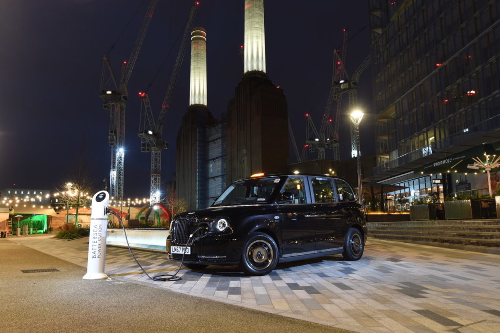 The new TX electric taxi at a charging point in front of Battersea Power Station