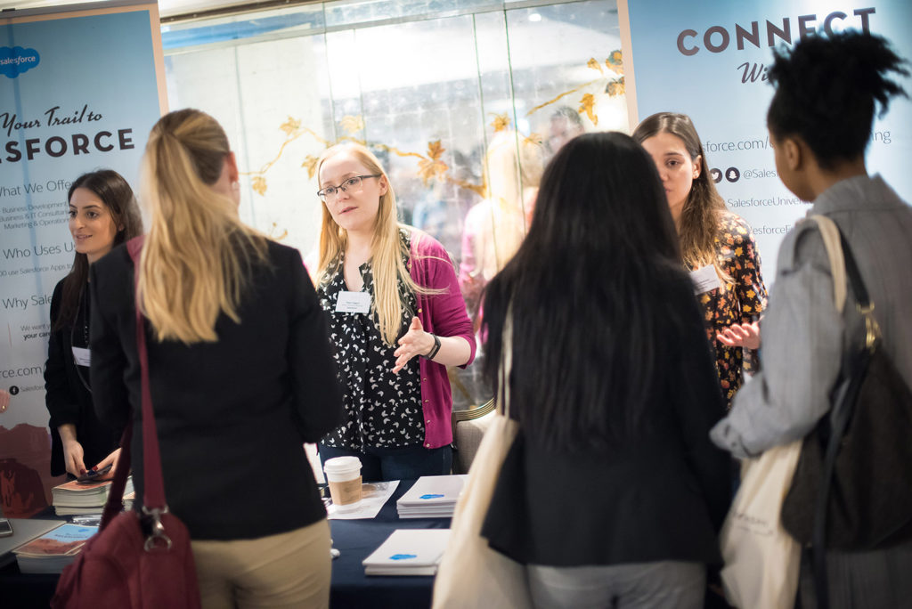 Female graduates talking to one of 30 exhibitors at Tomorrow's Tech Leaders Today